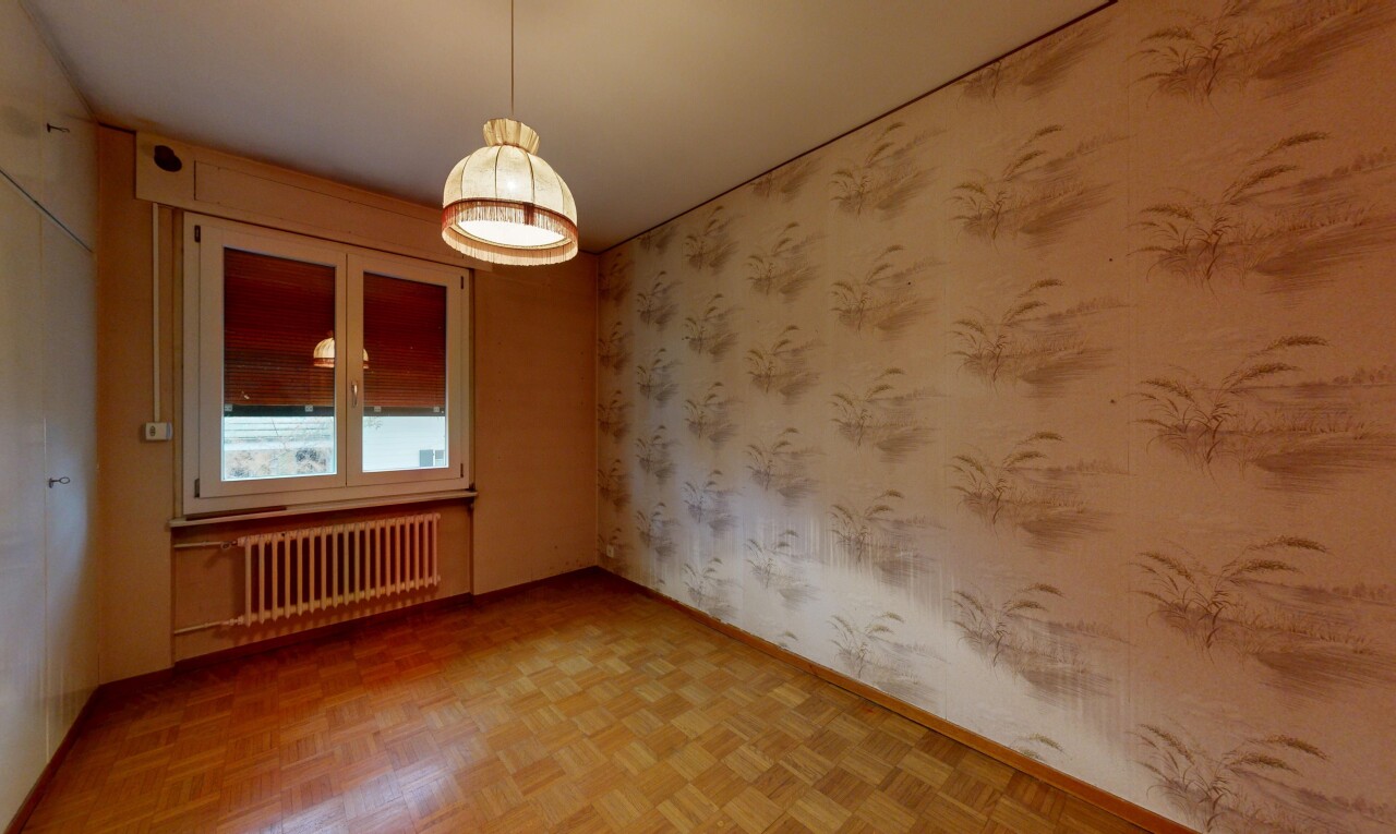 pièce vide avec mur en papier peint, wallpaper wall, parquet floor, radiateur, et lumière naturelle
