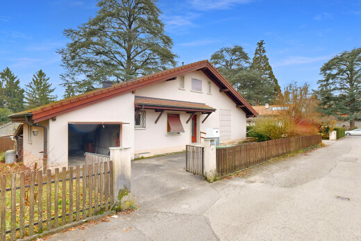 façade avec clôture, property visible, bardage en stuc, auvent, et day time