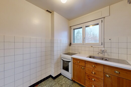 cuisine avec mur en carrelage, tile wall, cuisinière, armoires marron moyen, et plans de travail