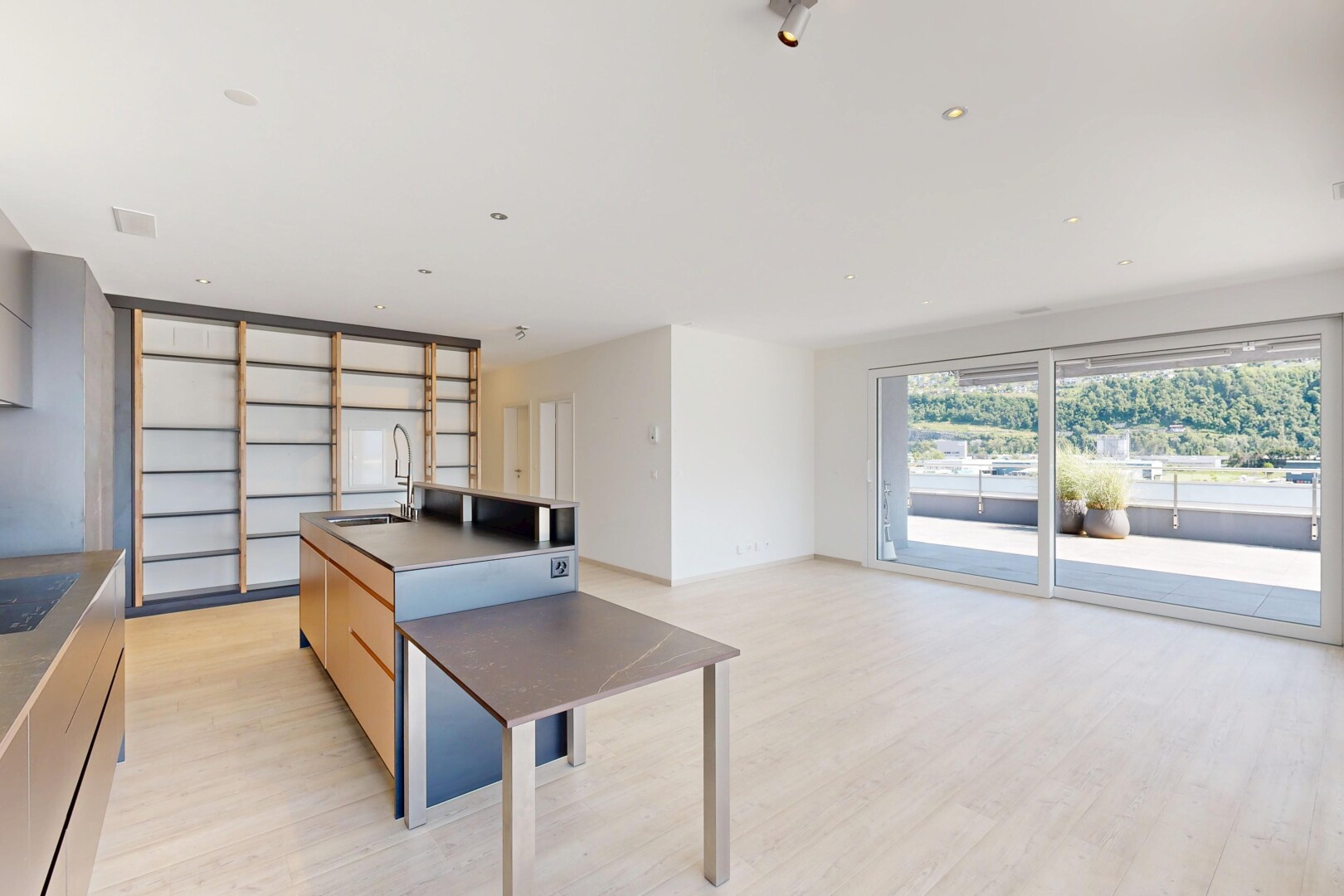 cuisine avec cloison sèche, drywall, light floor, sol en finition bois, et wood finish floor