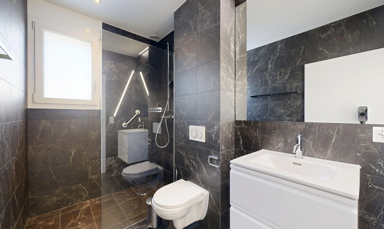 salle de bains avec mur en carrelage, tile wall, douche, salle de bain complète, et natural light