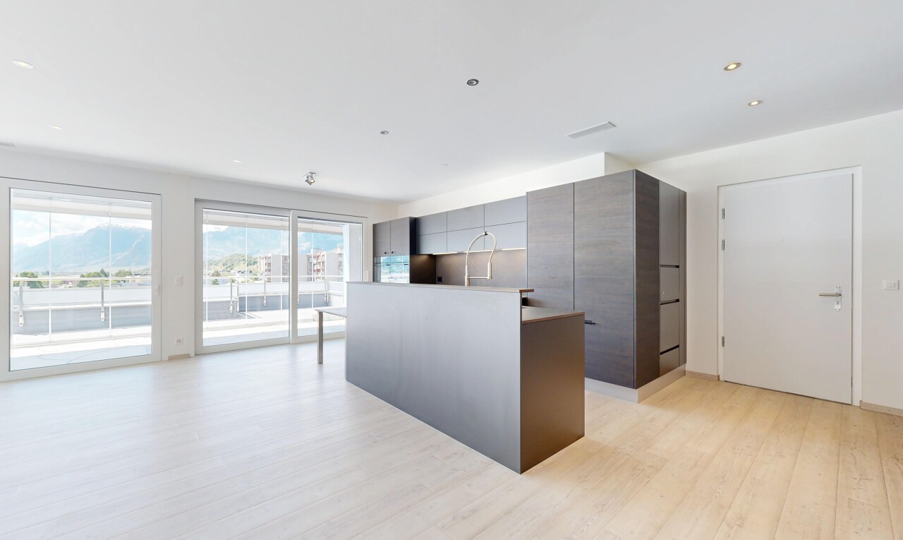 cuisine avec two heights countertops, light floor, sol en finition bois, wood finish floor, et armoires à panneau plat