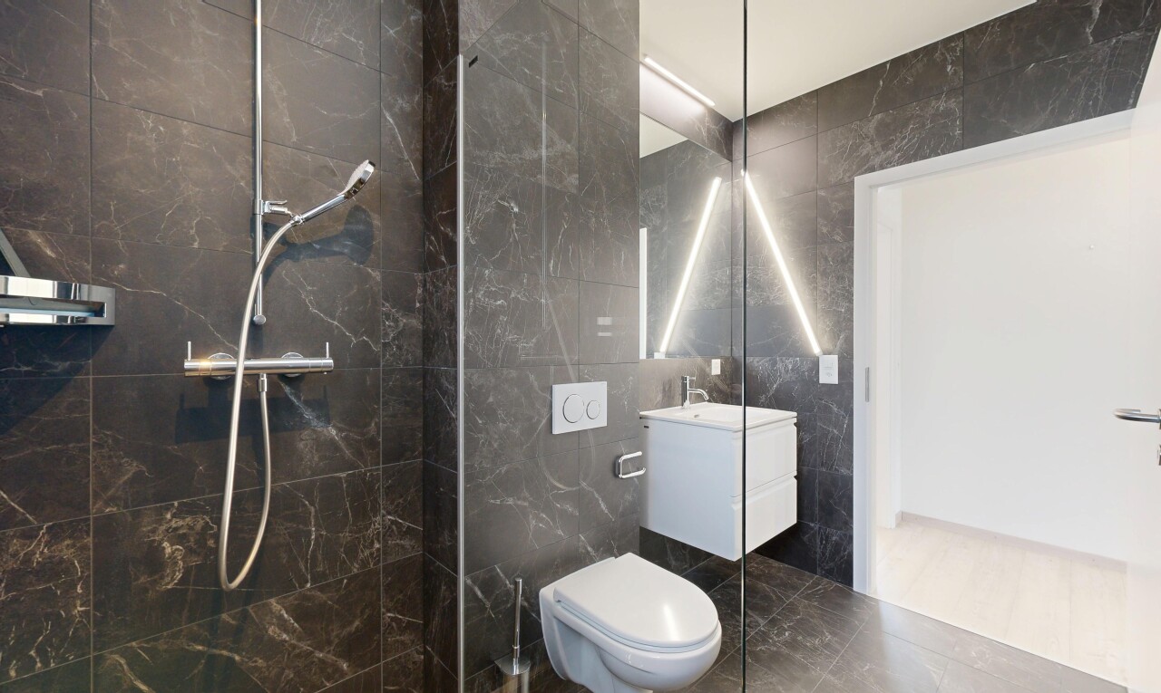 salle de bains avec mur en carrelage, tile wall, lavabo (ou coiffeuse selon le contexte), douche, et salle de bain complète