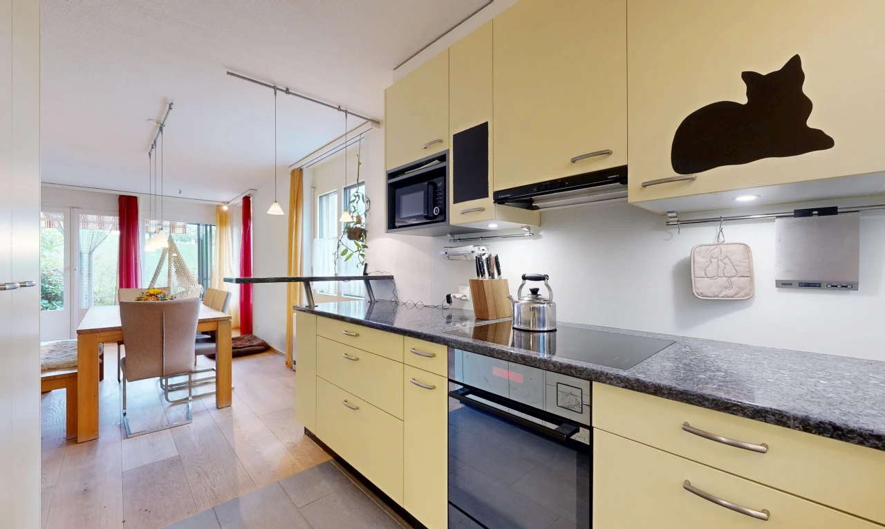 küche mit cremefarbene schränke, cream cabinets, dark countertops, ofen, und dunstabzugshaube