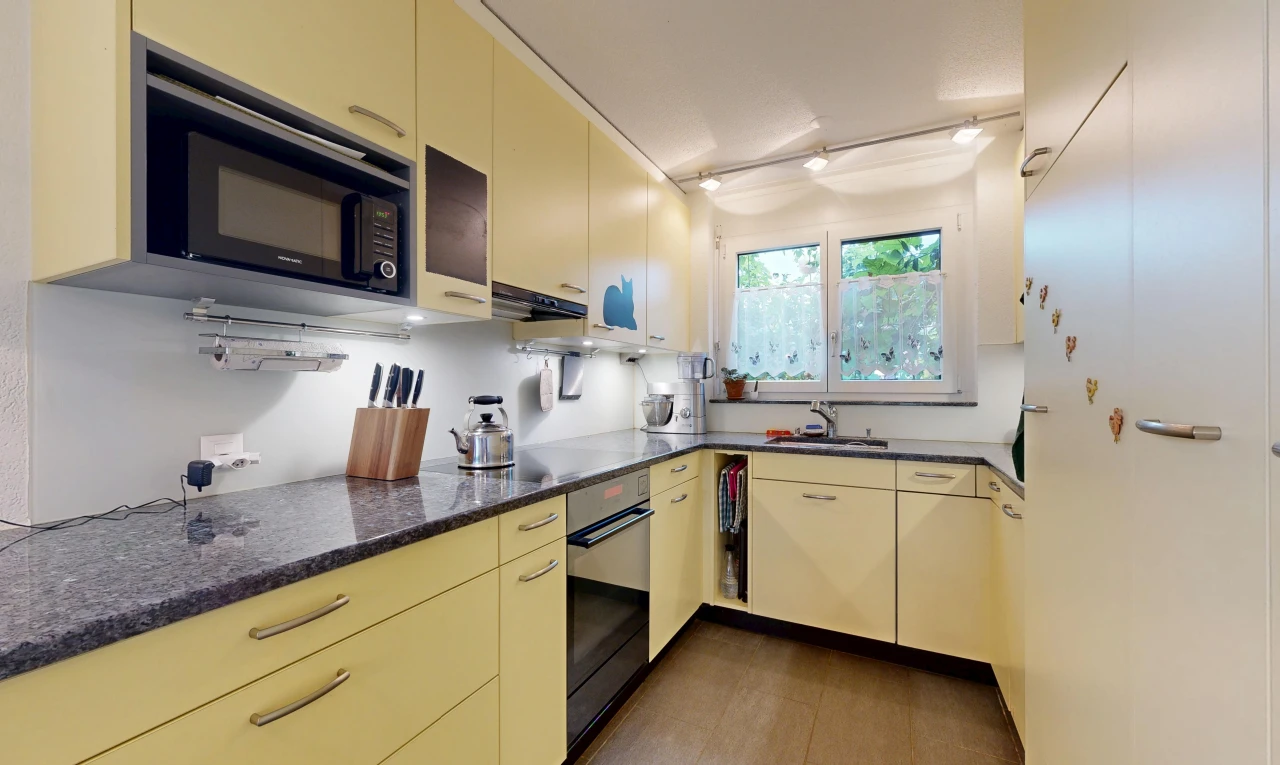 küche mit dark countertops, cremefarbene schränke, cream cabinets, ofen, und mikrowelle