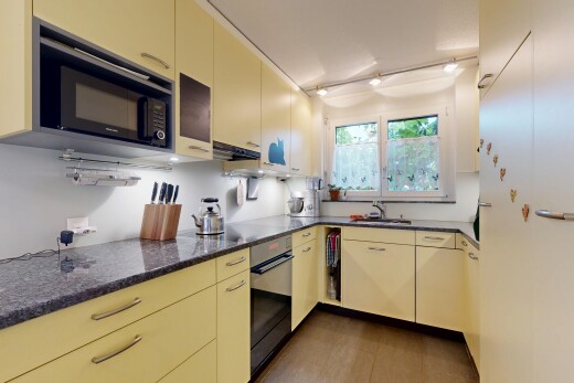 küche mit dark countertops, cremefarbene schränke, cream cabinets, ofen, und mikrowelle