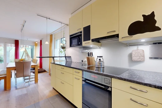 küche mit cremefarbene schränke, cream cabinets, dark countertops, ofen, und dunstabzugshaube