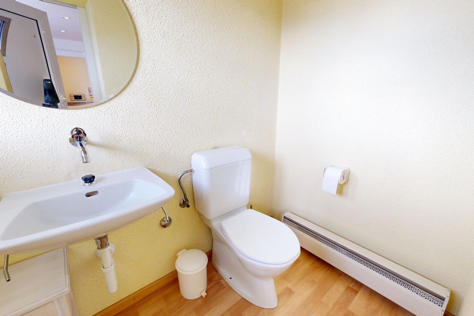 bathroom with a baseboard heating unit and wood finished floors