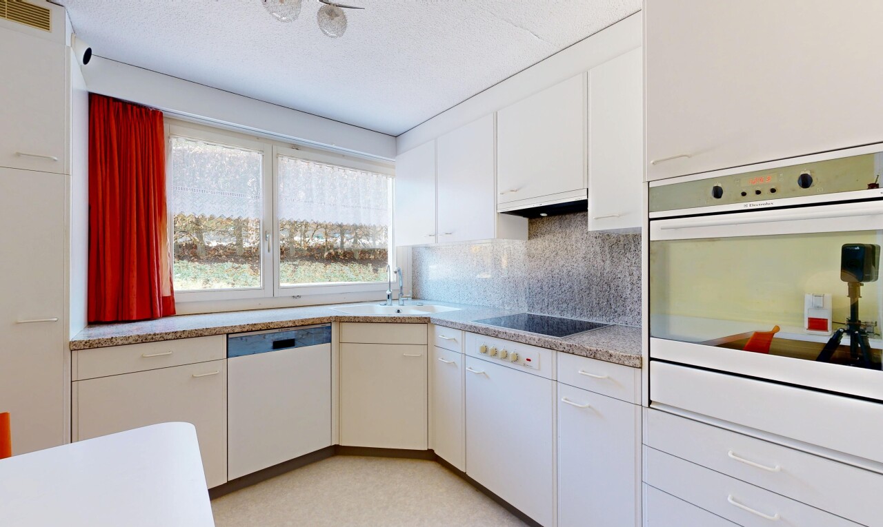 kitchen with white appliances, white cabinetry, decorative backsplash, light floors, and under cabinet range hood