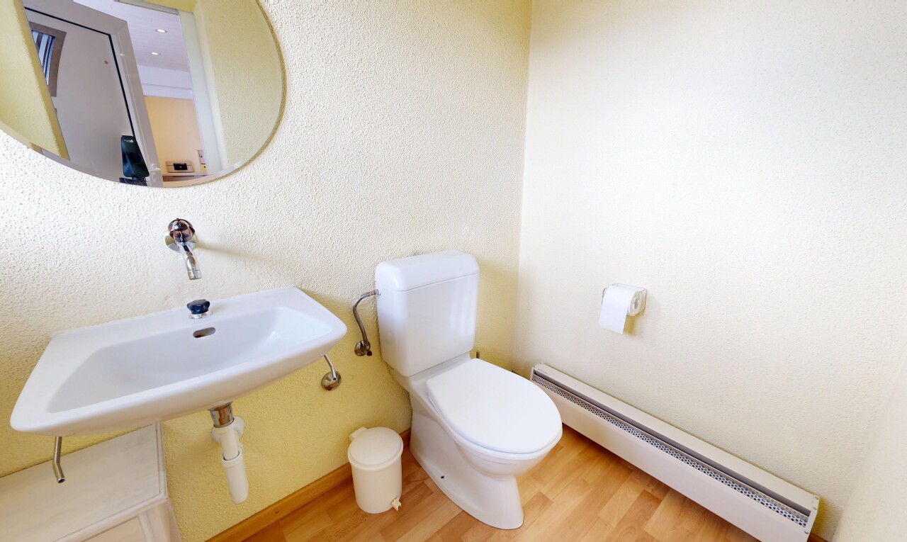 bathroom with a baseboard heating unit and wood finished floors