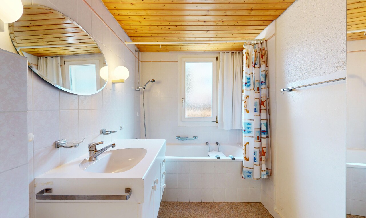 bathroom with vanity, plenty of natural light, tiled shower / bath combo, wood ceiling, and tile walls
