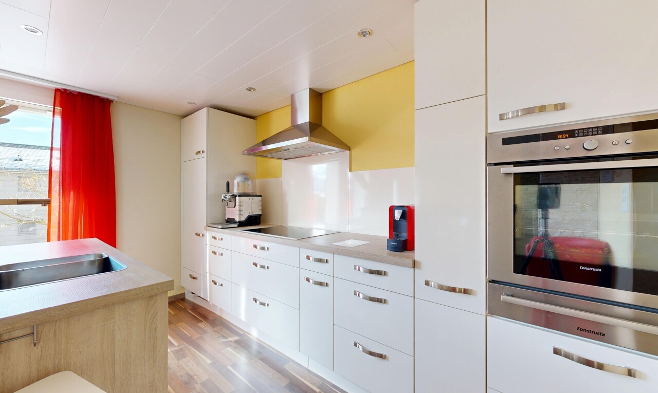 kitchen featuring wall chimney range hood, stainless steel oven, white cabinetry, light wood finished floors, and a warming drawer