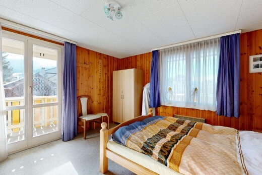 zimmer / schlafzimmer mit holzwand, wood wall, inside property, außenzugang, und teppich
