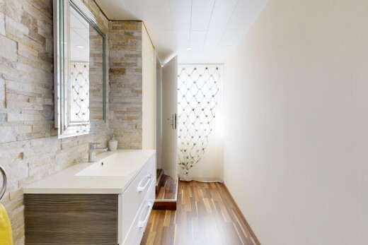 salle de bains avec cloison sèche, drywall, miroir, lavabo (ou coiffeuse selon le contexte), et stone wall