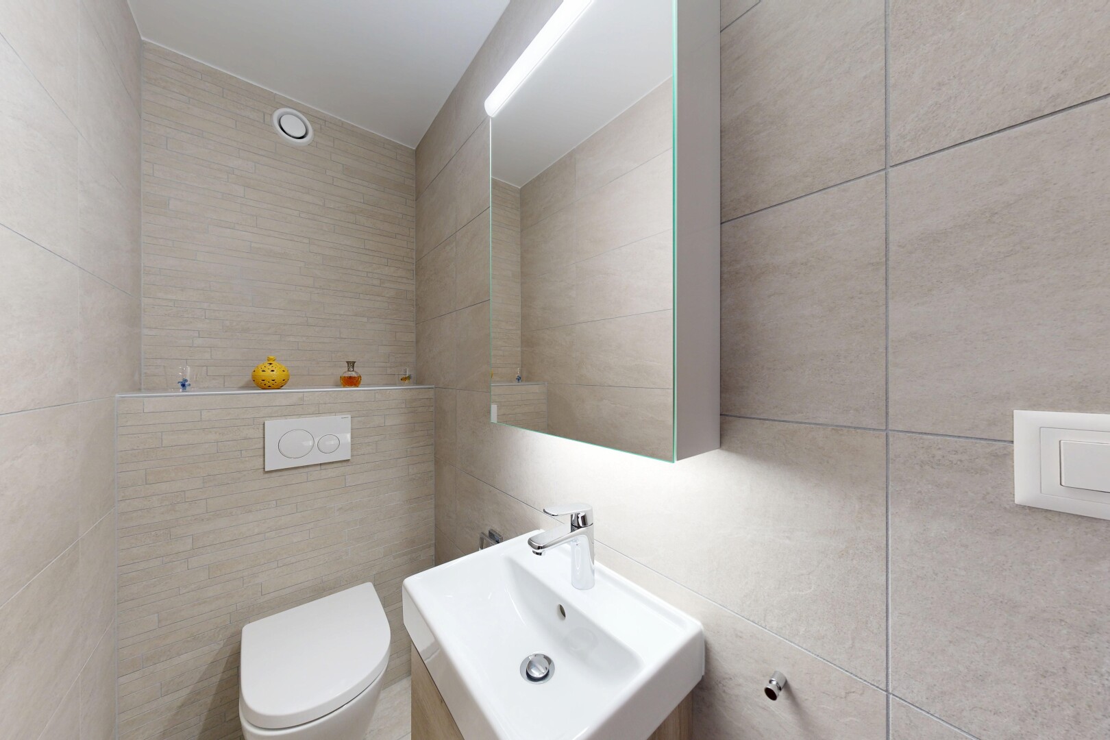 salle de bains avec mur en carrelage, tile wall, inside property, évier, et toilette