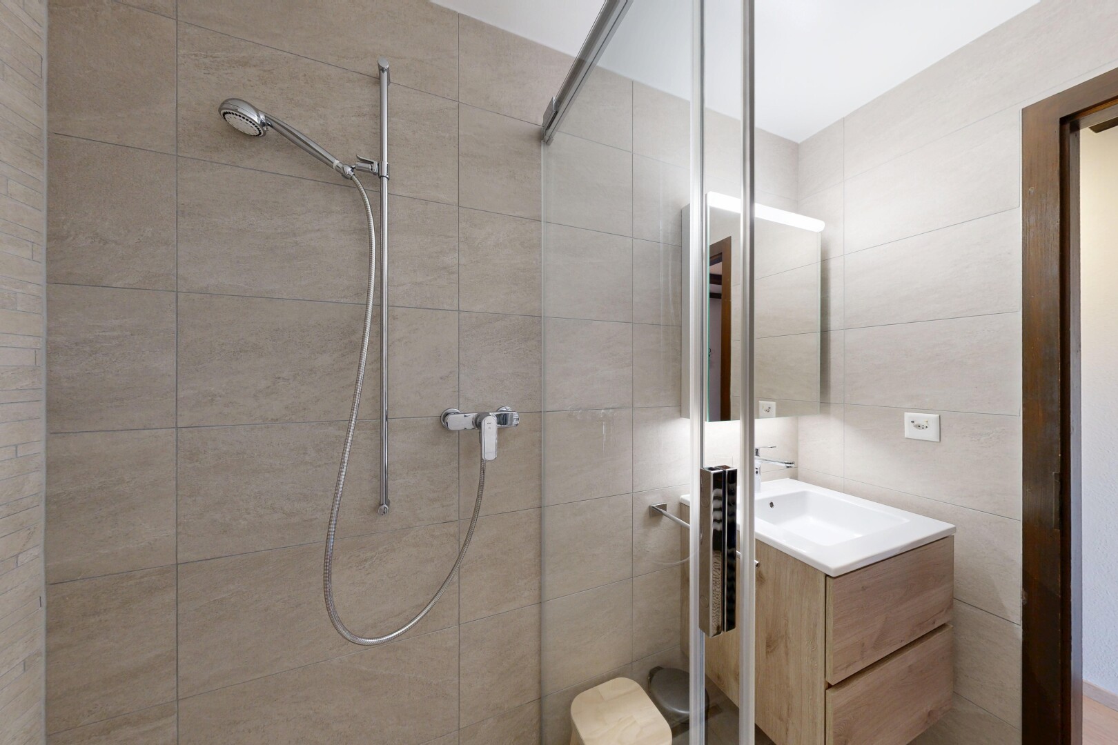 salle de bains avec douche, miroir, salle de bain complète, lavabo (ou coiffeuse selon le contexte), et inside property