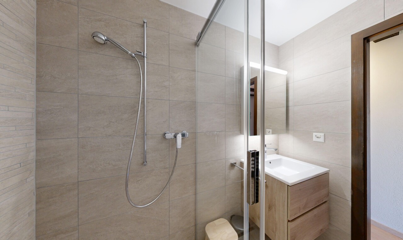 salle de bains avec douche, miroir, salle de bain complète, lavabo (ou coiffeuse selon le contexte), et inside property
