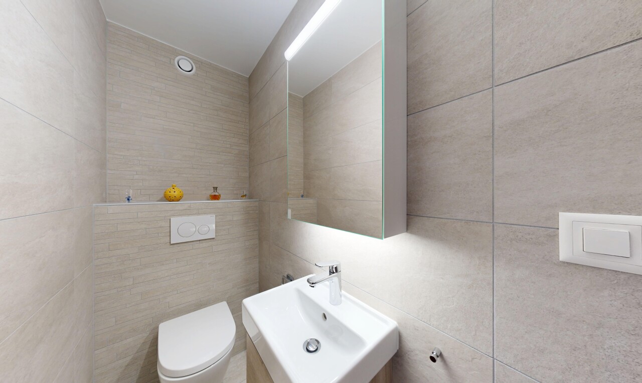 salle de bains avec mur en carrelage, tile wall, inside property, évier, et toilette