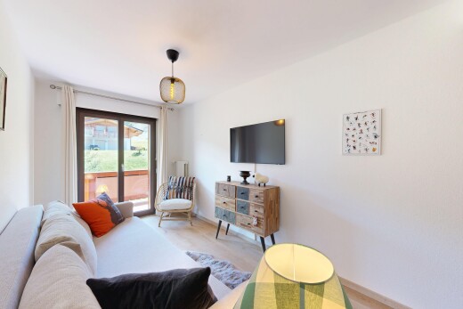 salon avec télévision, inside property, cloison sèche, drywall, et lumière naturelle