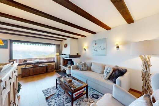living area featuring beamed ceiling and wood finished floors