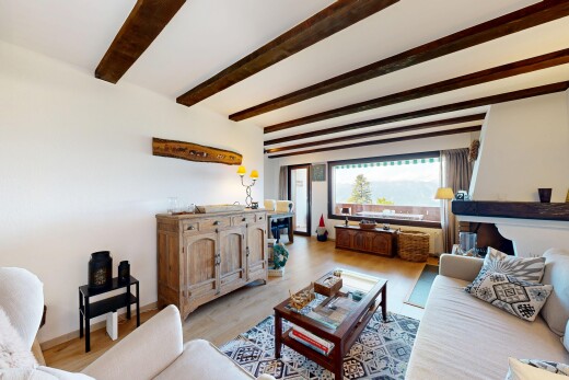 living area with wood finished floors and beam ceiling