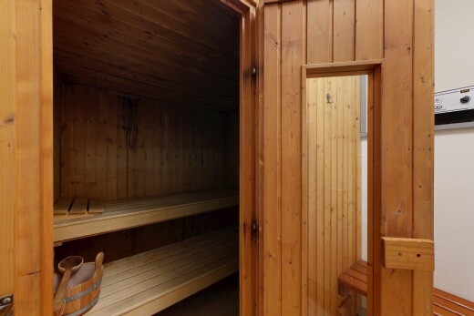 unfurnished room with wooden walls, a sauna / steam room, and wood ceiling