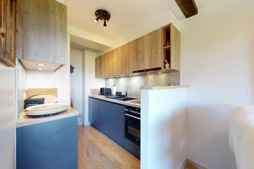 kitchen with light countertops, open shelves, light wood-style flooring, wall oven, and two tone cabinets