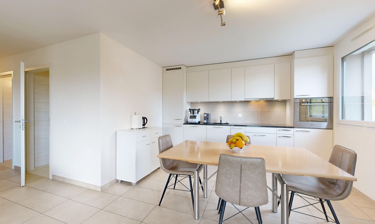 cuisine avec four, armoires à panneau plat, drywall, cloison sèche, et armoires blanches