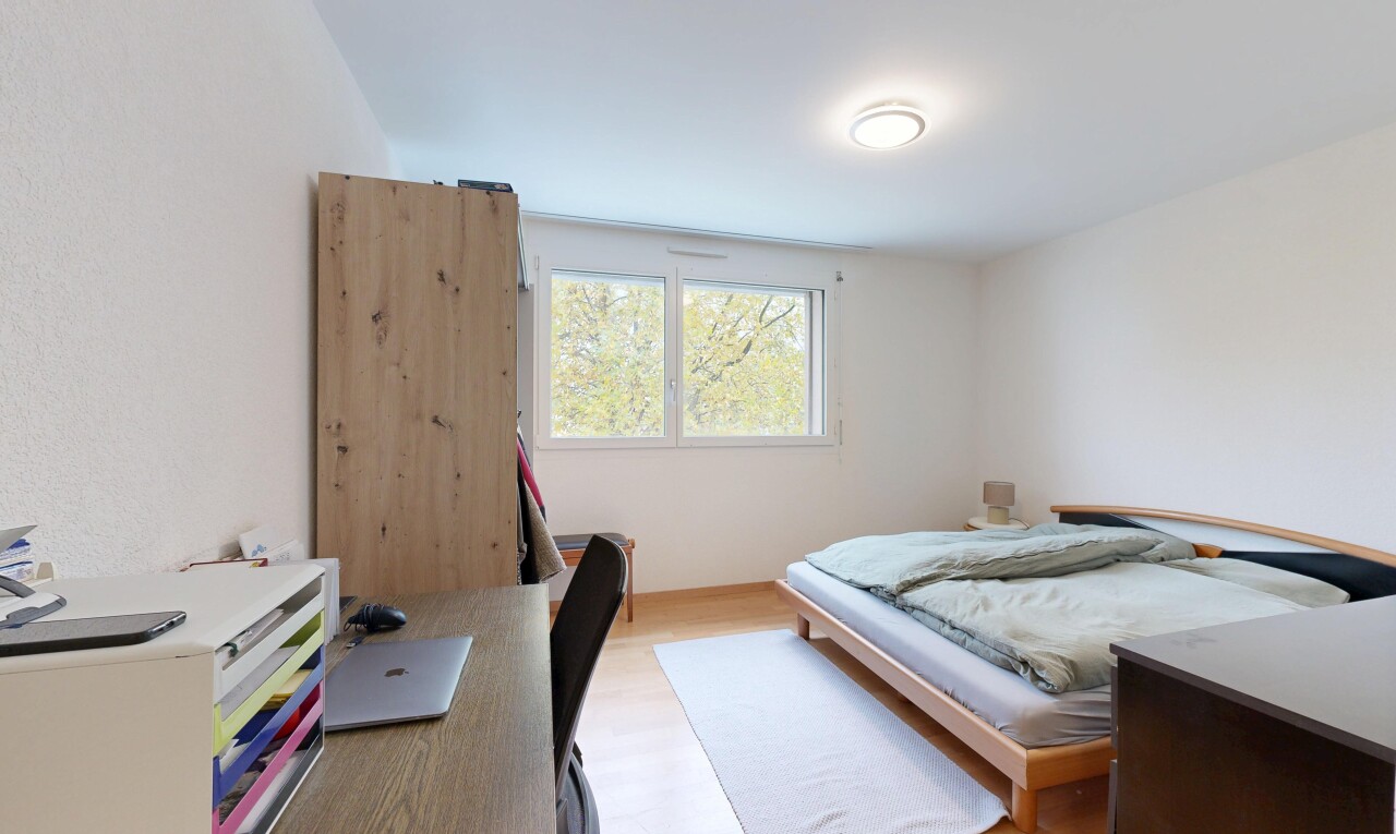 chambre avec espace bureau, natural light, lumière naturelle, inside property, et wood finish floor