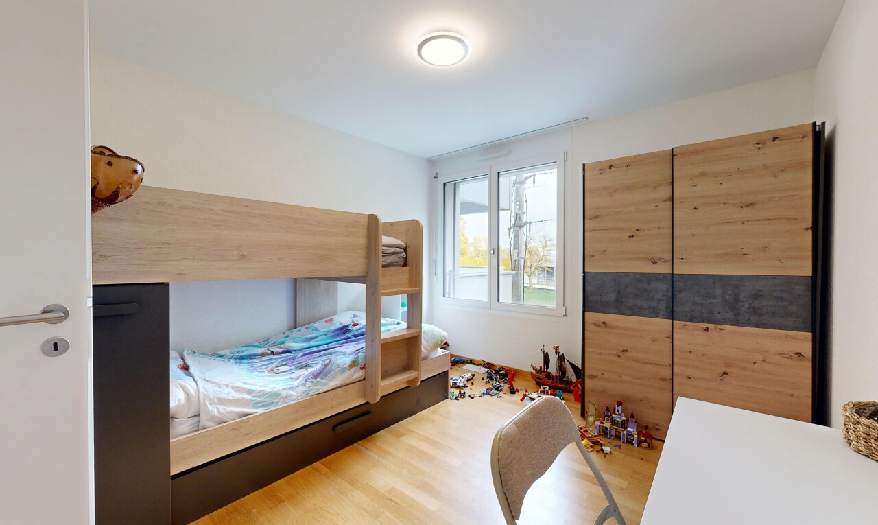 chambre avec natural light, lumière naturelle, wood finish floor, sol en finition bois, et drywall
