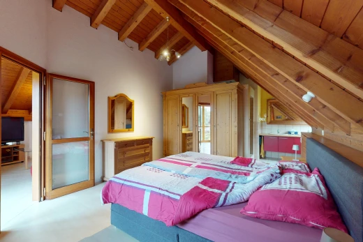 zimmer / schlafzimmer mit balkendecke, fernseher, teppich, dachschräge, und holzdecke