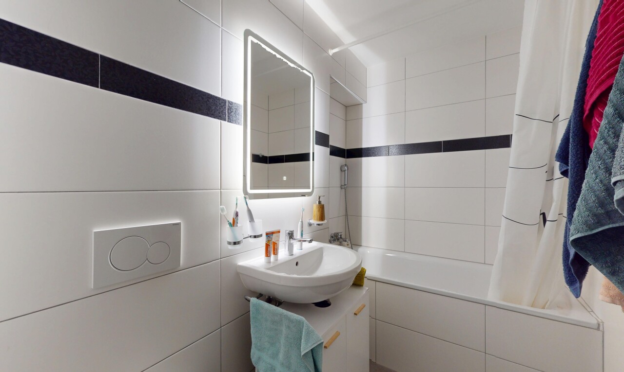 bathroom featuring tiled shower / bath, vanity, and tile walls