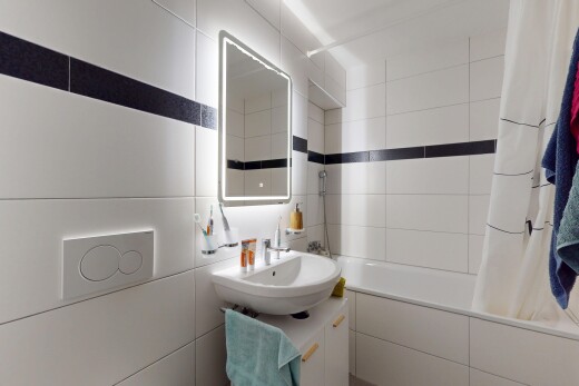 bathroom featuring tiled shower / bath, vanity, and tile walls