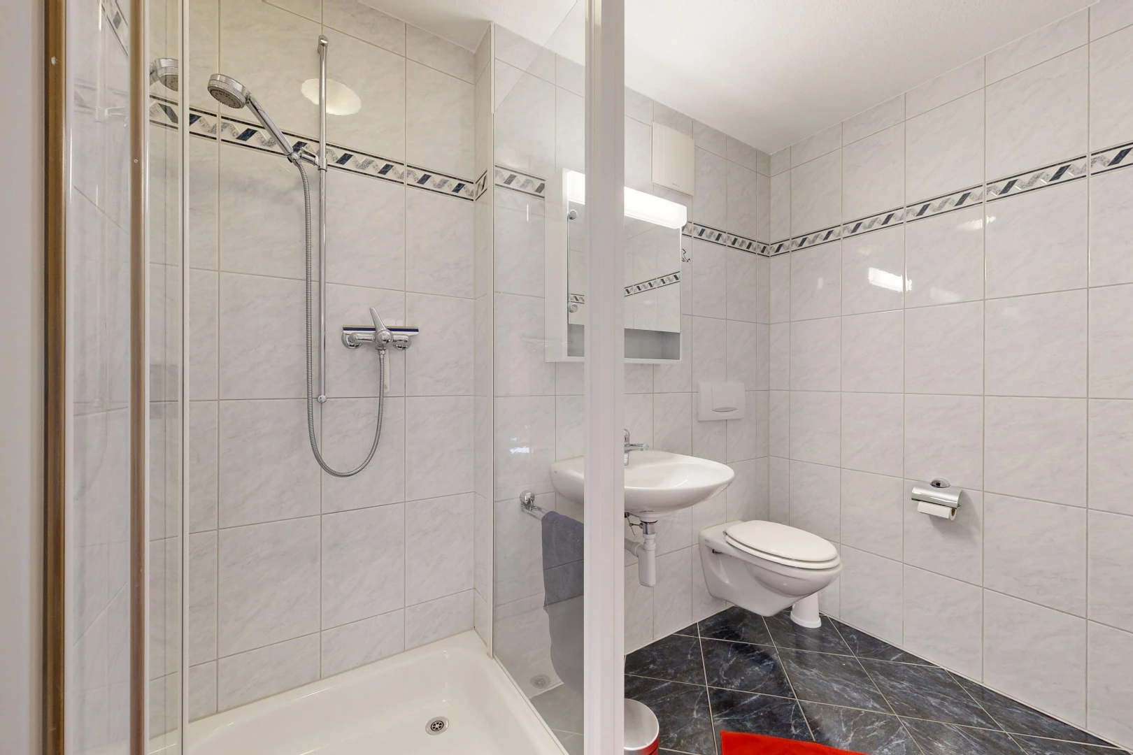 bathroom with a shower stall and tile walls
