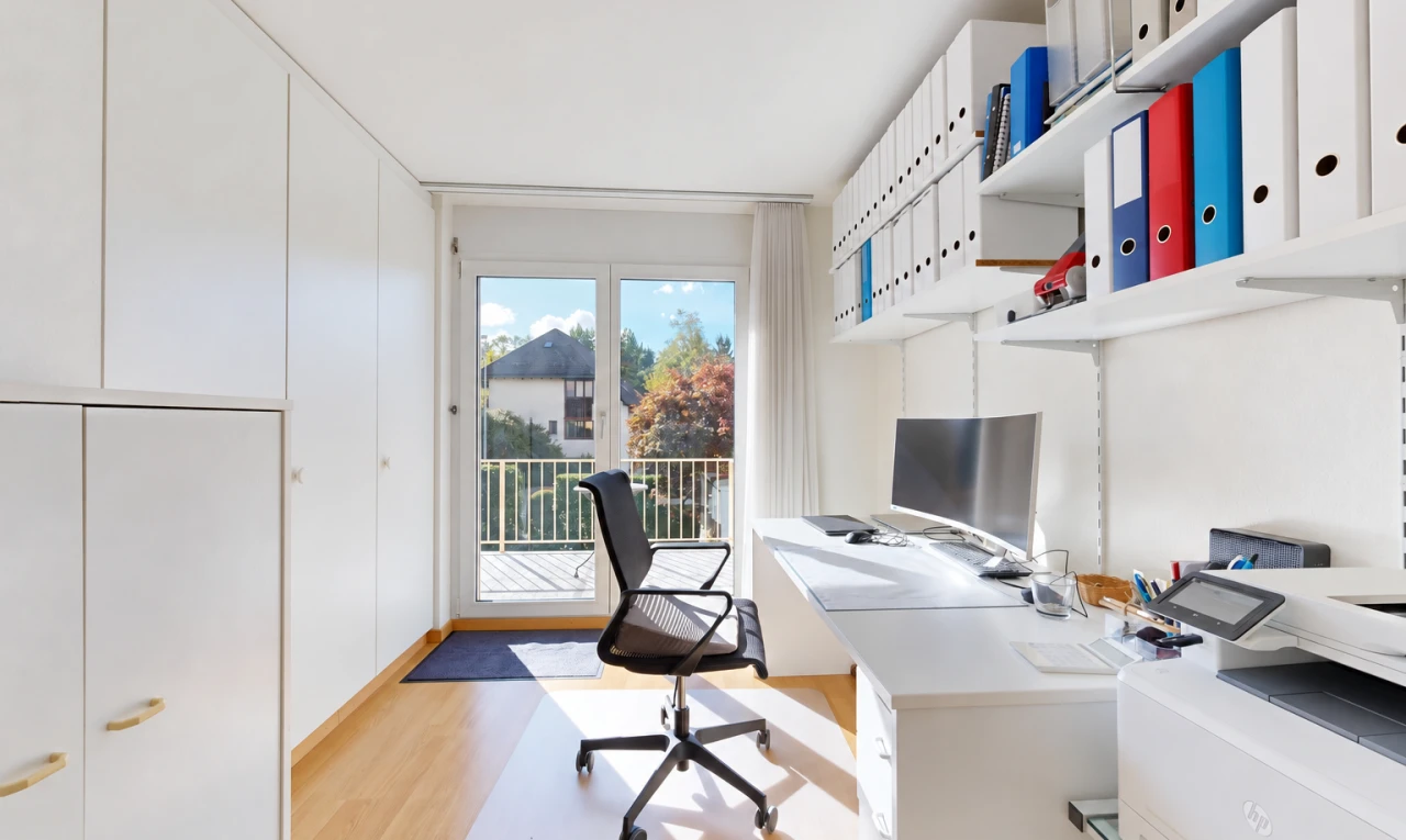 home office with built in study area, light wood-style floors, and built in shelves