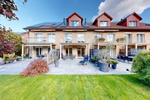 view of home featuring solar panels, a balcony, a patio area, and a yard