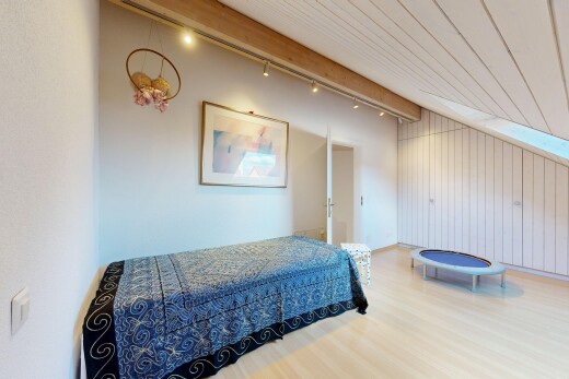 room / bedroom with light wood finished floors, wood walls, and track lighting