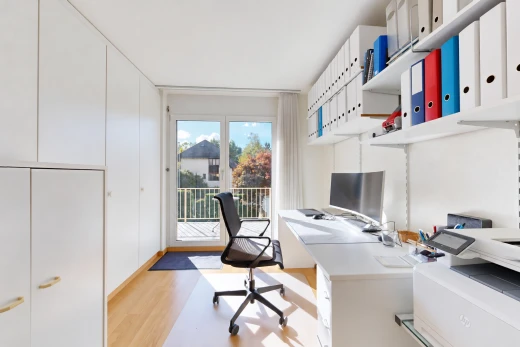 home office with built in study area, light wood-style floors, and built in shelves