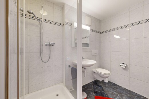 bathroom with a shower stall and tile walls