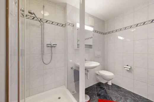 bathroom with a shower stall and tile walls