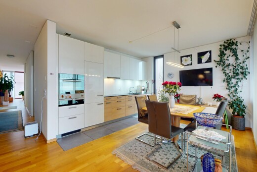 küche mit fernseher, ofen, holzfußboden, und schränke mit flachen paneelen