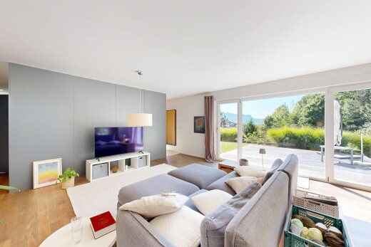 wohnzimmer mit inside property, holzfußboden, wood finish floor, fernseher, und natürliches licht