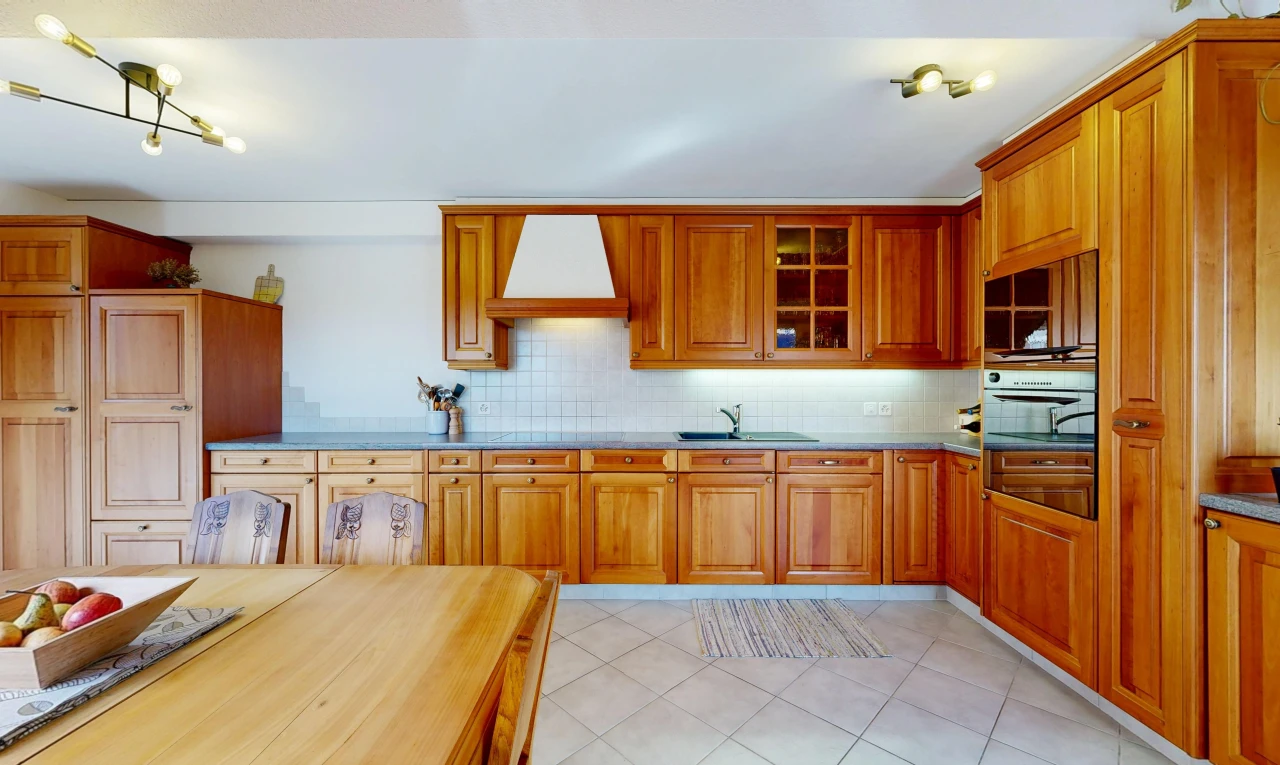 cuisine avec hotte, medium brown cabinets, armoires marron moyen, light floor, et raised cabinets
