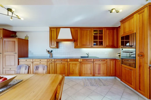 cuisine avec hotte, medium brown cabinets, armoires marron moyen, light floor, et raised cabinets