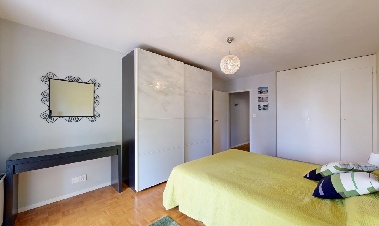 chambre avec cloison sèche, drywall, deux placards, sol en finition bois, et wood finish floor
