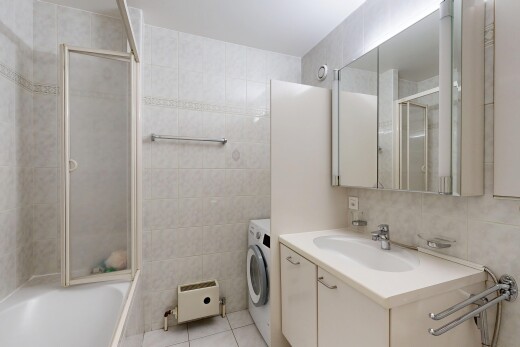 salle de bains avec mur en carrelage, tile wall, miroir, lavabo (ou coiffeuse selon le contexte), et salle de bain complète
