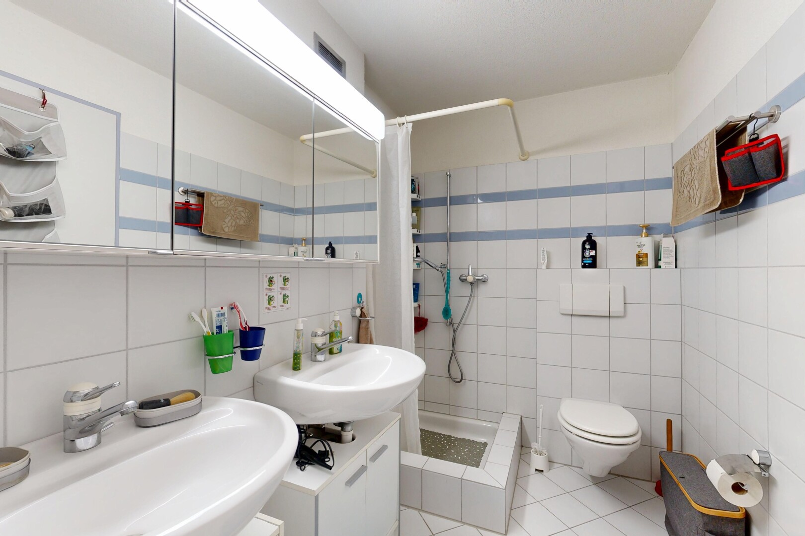 salle de bains avec miroir, douche, inside property, salle de bain complète, et tile wall