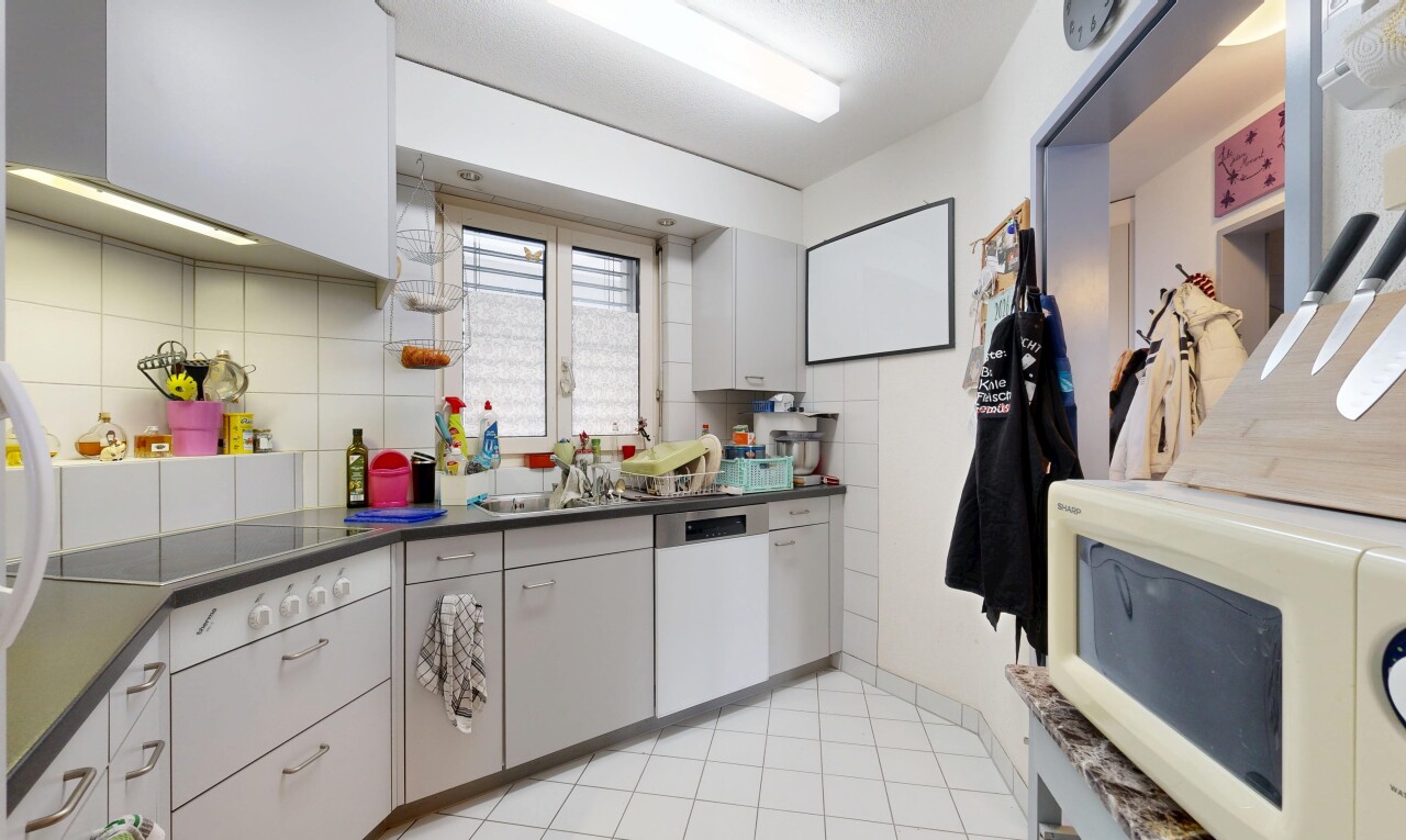 cuisine avec plans de travail, dark countertops, micro-ondes, light floor, et inside property