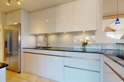 küche mit weiße schränke, kühlschrank, fliesenboden, tile floor, und pendelleuchte