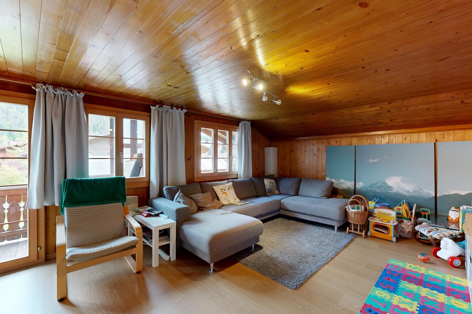 wohnzimmer mit vaulted ceiling, dachschräge, inside property, wood finish floor, und holzfußboden